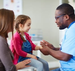 Doctor talking to a young girl and her mom
